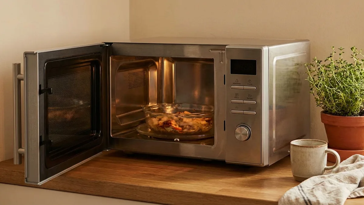 Open microwave door showing a glass bowl of food inside