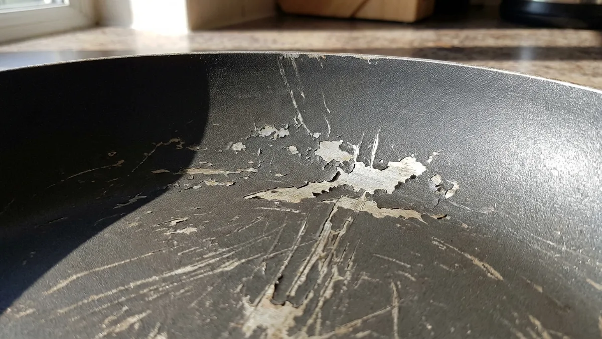 Teflon nonstick cookware on a gas stove showing the coated frying pan surface up close